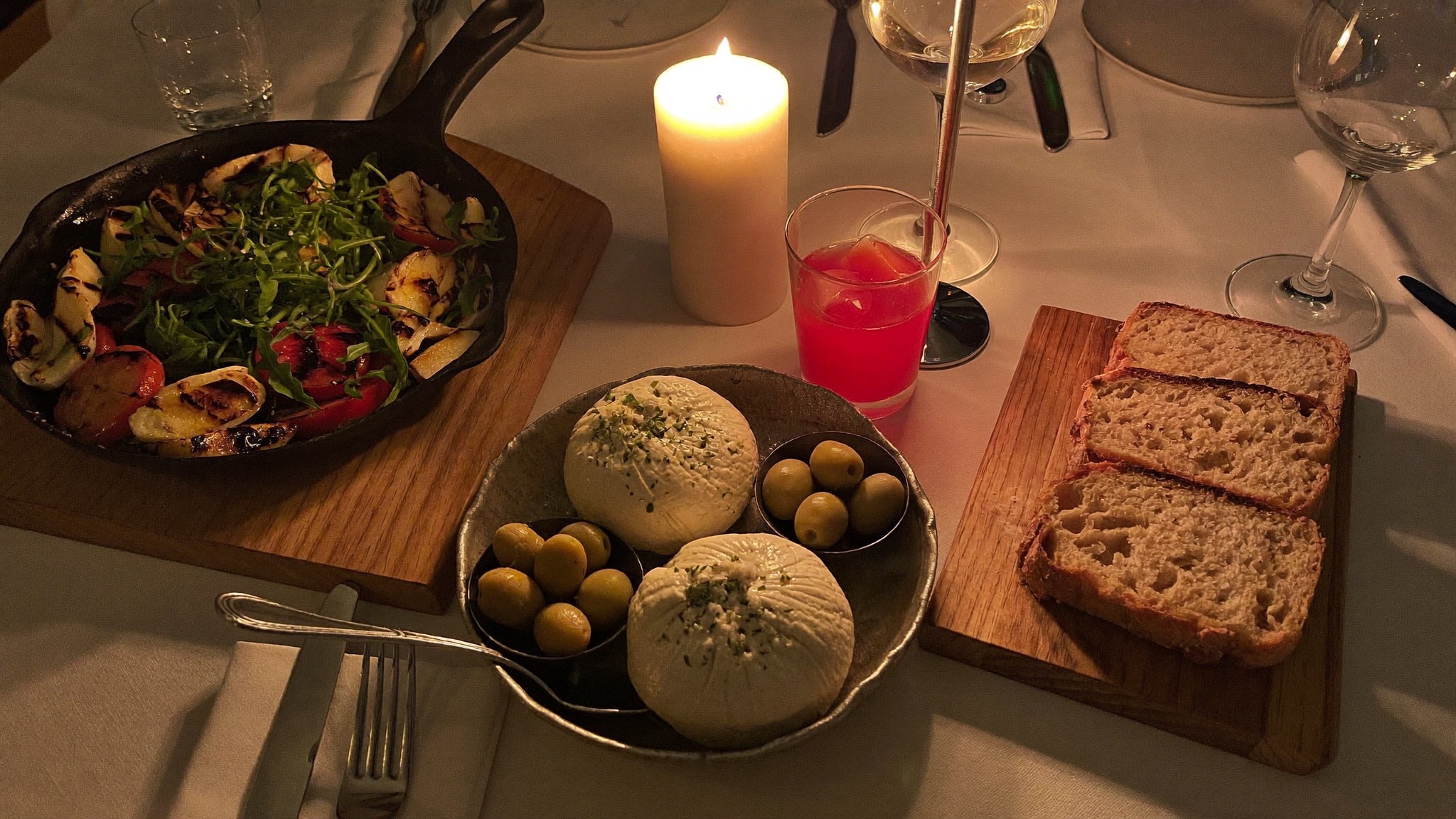 Antipasti bei Kerzenlicht: Burrata, Oliven, gegrilltes Gemüse und Brot